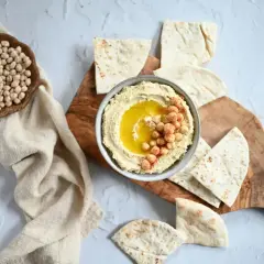 Krämig hummus med kikärtor och olivolja, serverad med pitabröd. Ett perfekt hummus recept för alla tillfällen.