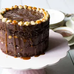 Enkel tårta choklad med kolasås som rinner ner. Toppad med nötter och virvlar av choklad. Perfekt för en fika.