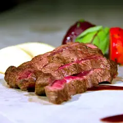 Saftig flat iron steak, perfekt medium-rare, serverad med krämigt potatismos och röda grönsaker.