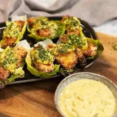 Krispiga bitar i salladsblad toppade med en krämig sås. Perfekt tillbehör till ditt remouladsås recept.