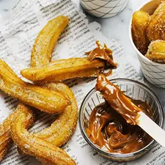 Krispiga churros med socker, redo att doppas i kolasås. Ett perfekt churros recept för hemmabruk.