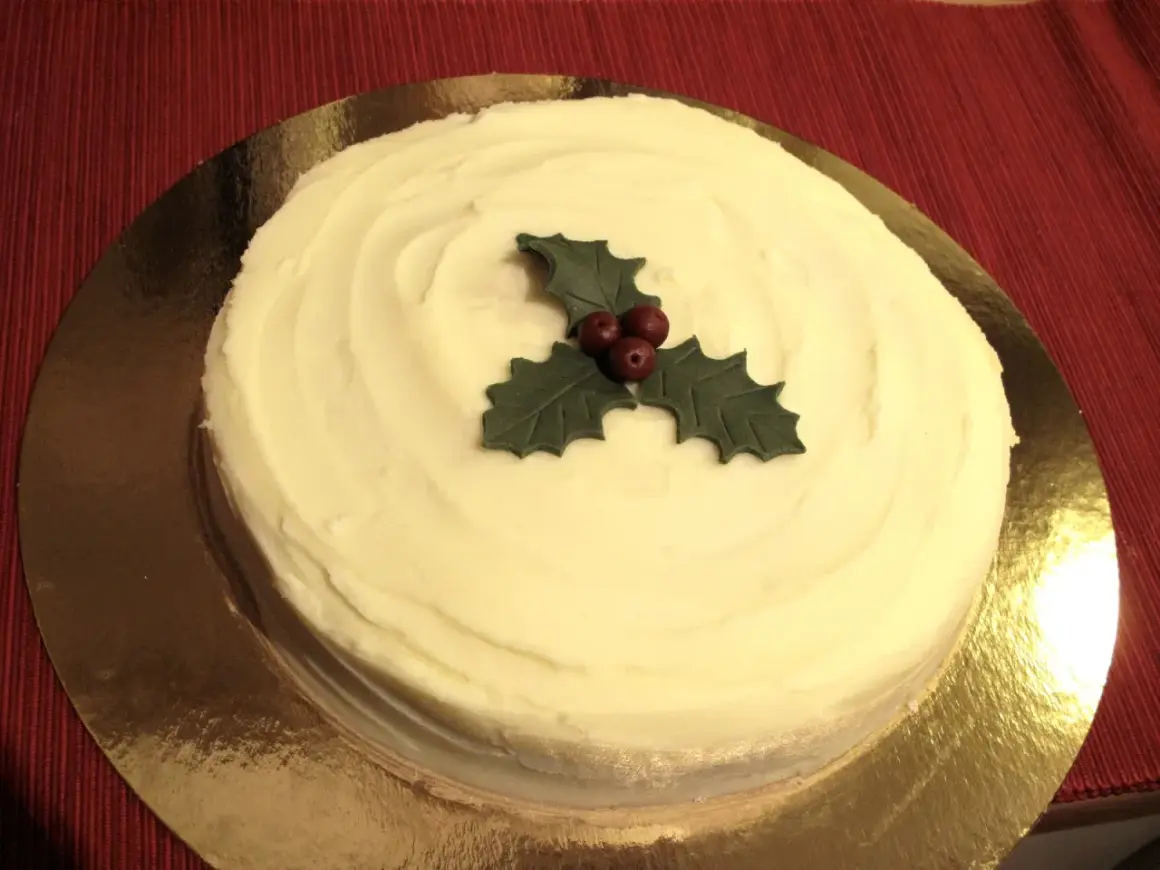 En krämig tårta med vit glasyr, dekorerad med en julstjärna av marsipan. Perfekt för julfikat!