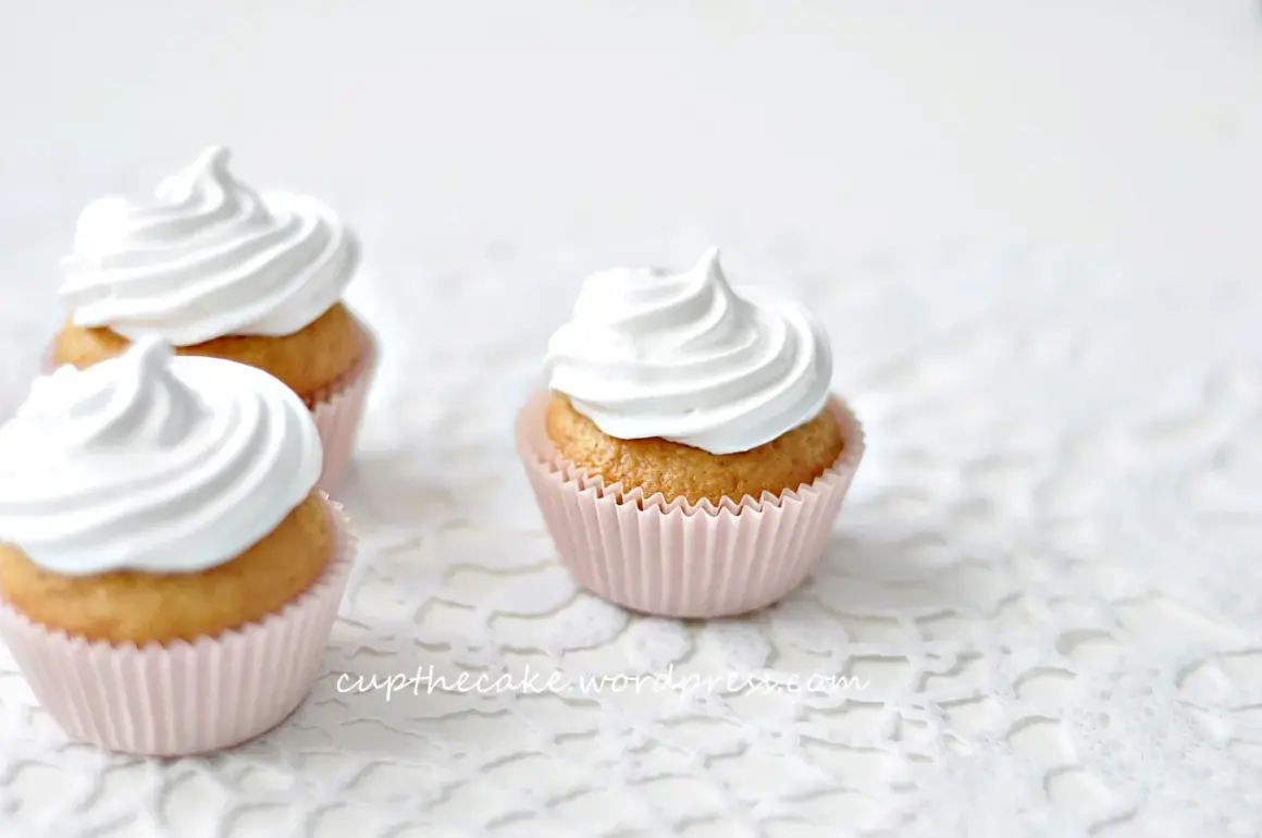 Tre fluffiga muffins med vit frosting, perfekta för ett enkelt frosting recept.