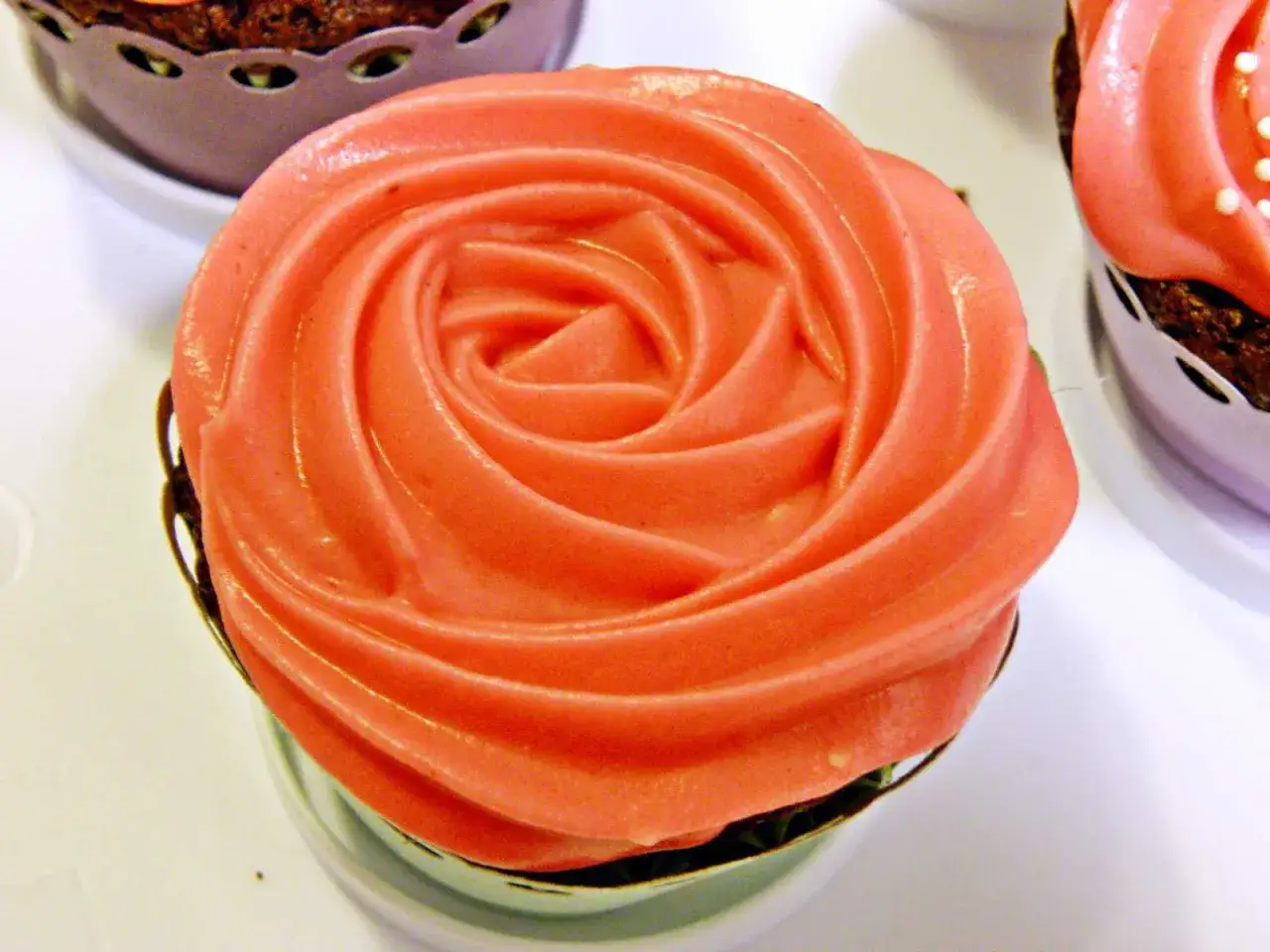 En cupcake med rosa frosting formad som en ros. Perfekt för ett enkelt frosting recept.