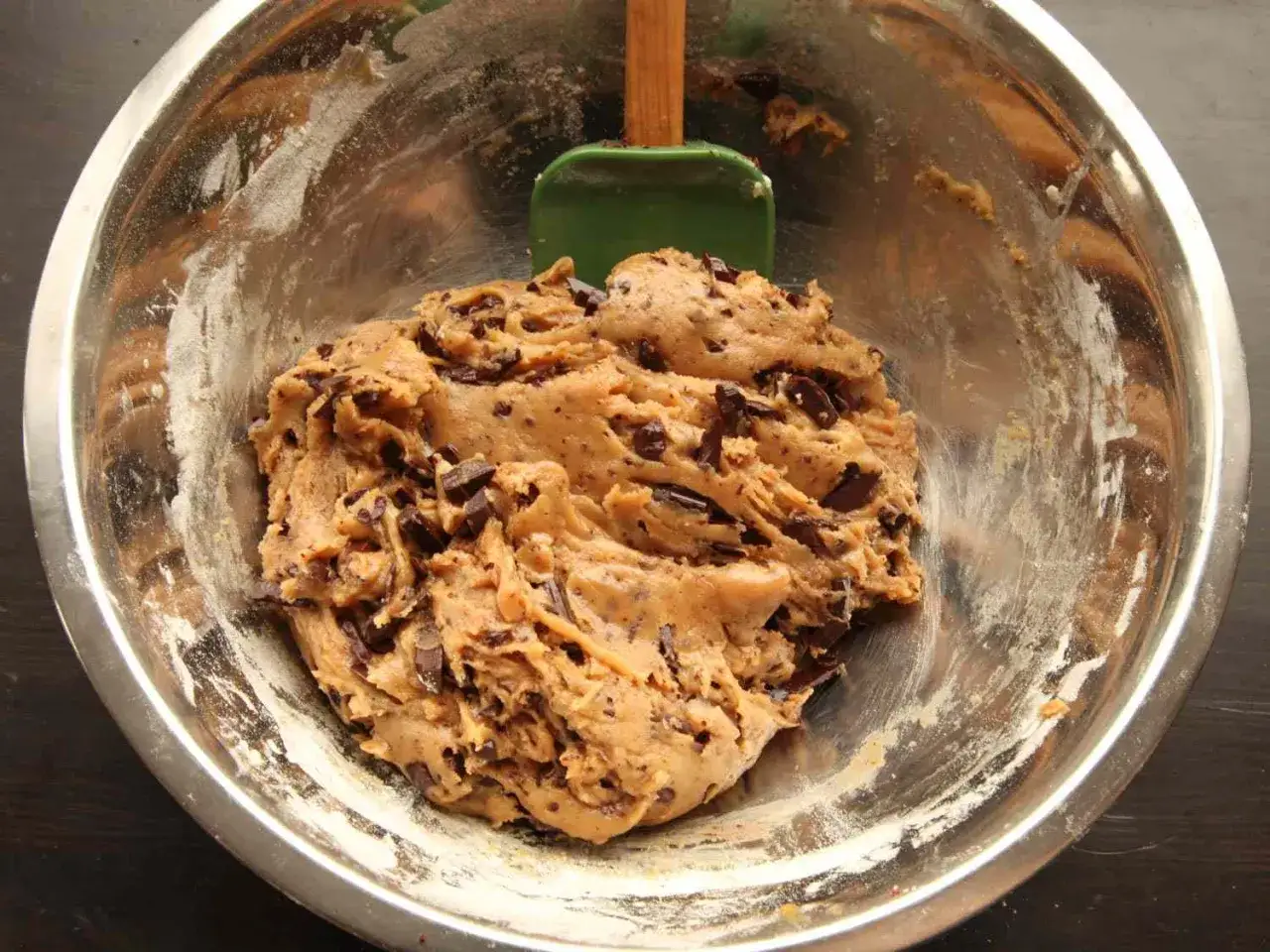 Chokladdeg i en skål, redo att baka. En grön slickepott ligger bredvid.