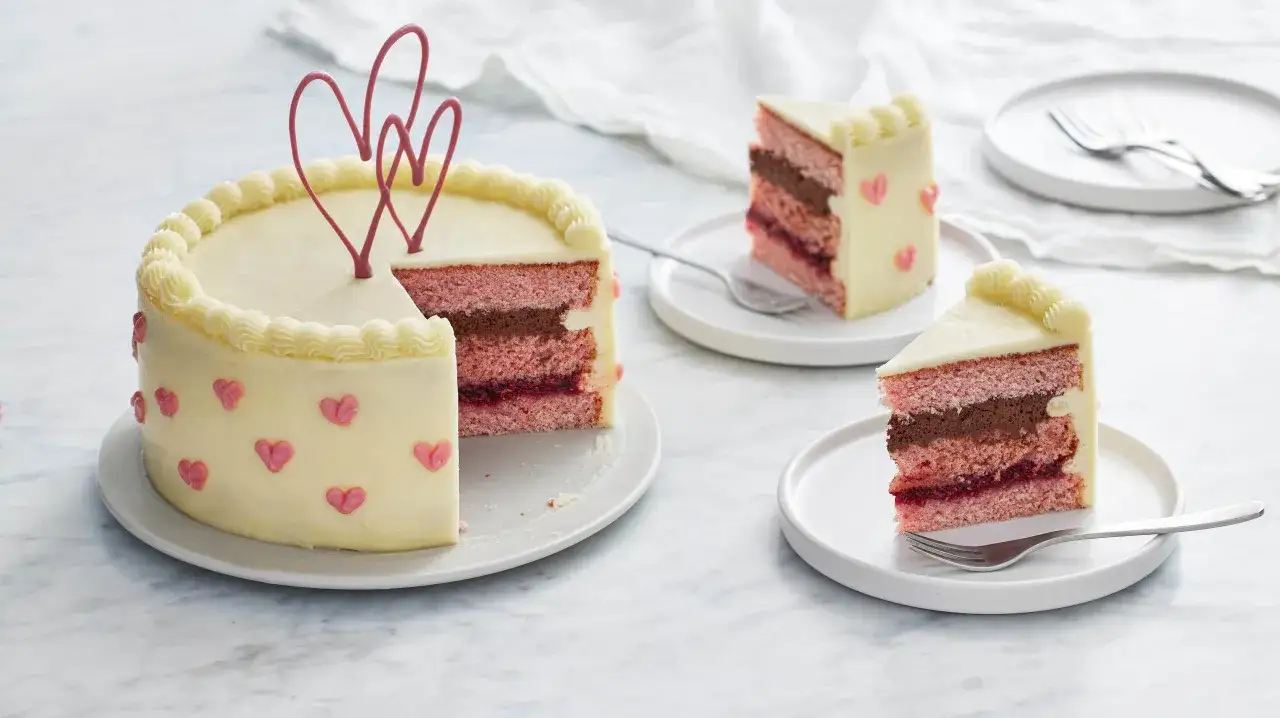 En vacker tårta med rosa och chokladlager, dekorerad med hjärtan. Fyllning tårta med krämig glasyr och hjärtdekorationer.